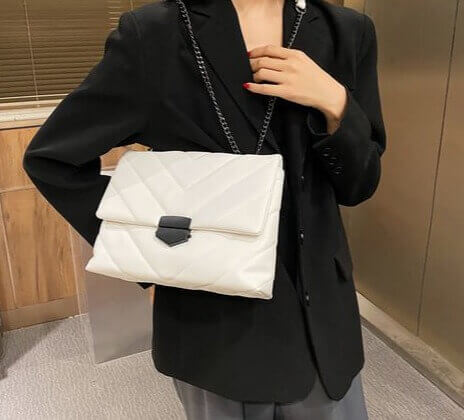 Woman carrying a V Embossed Flip Crossbody White