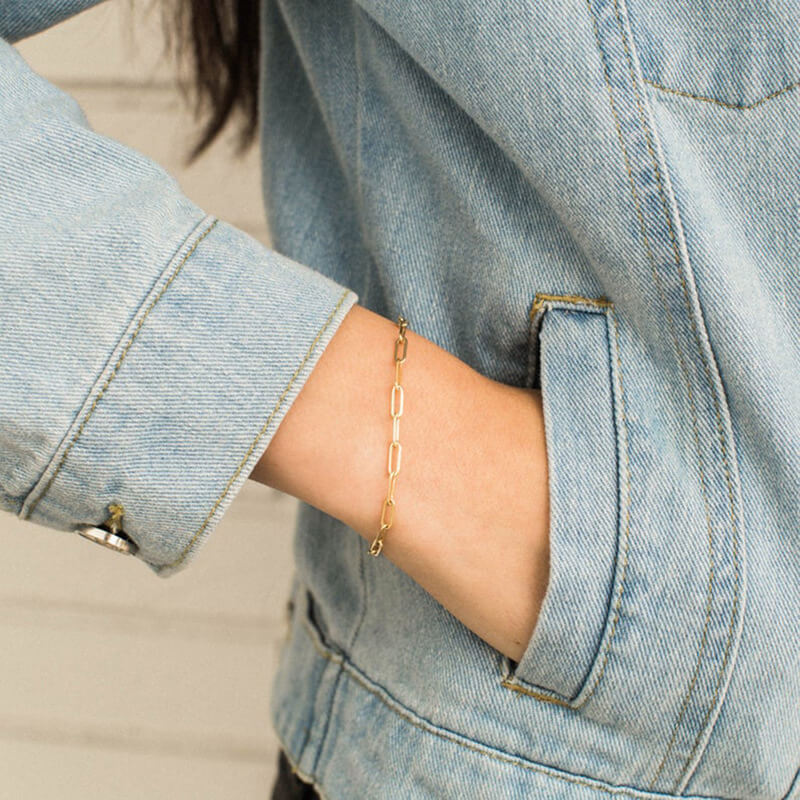 Model wearing gold paperclip bracelet