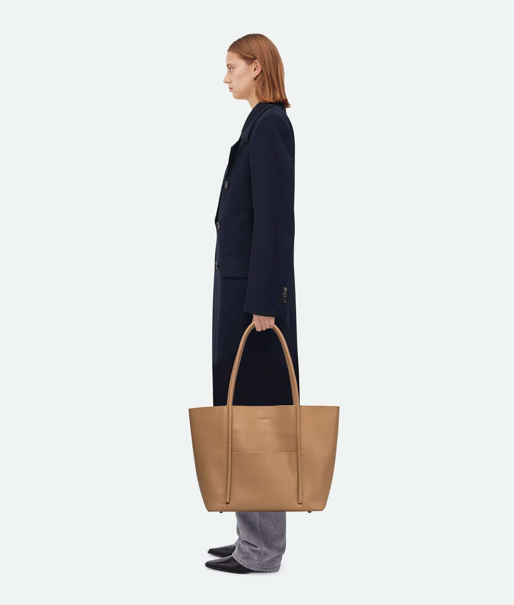 Model carrying a Brown leather tote bag