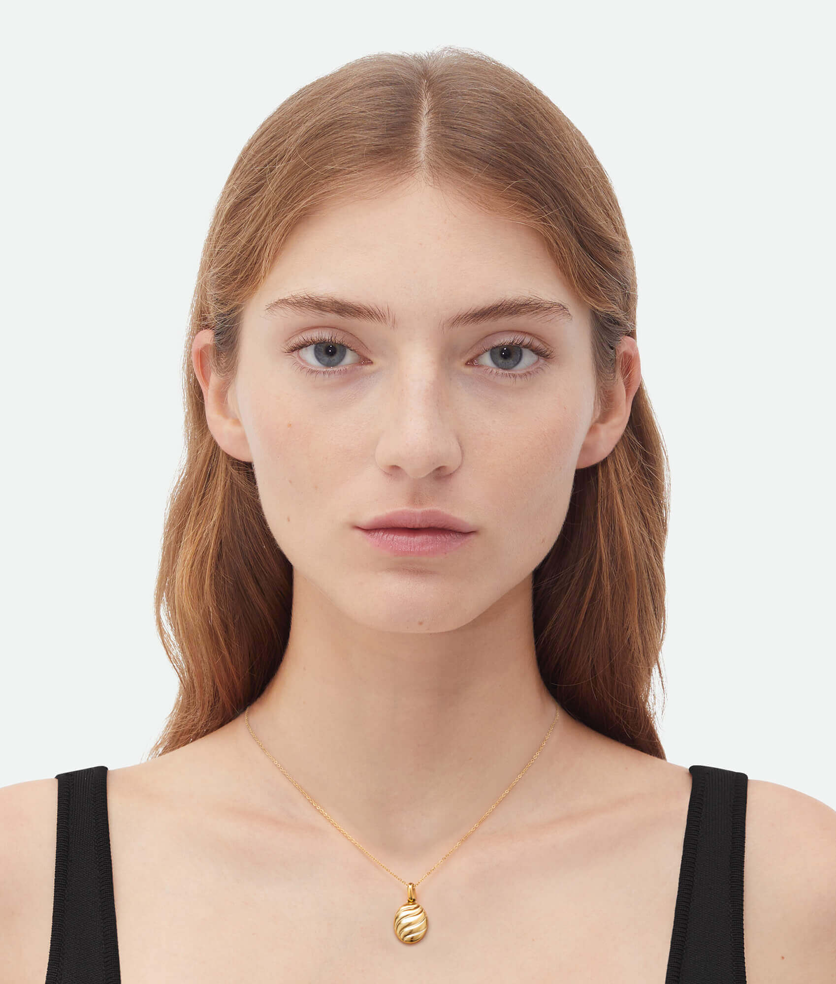 model wearing a gold necklace with croissant shaped pendant