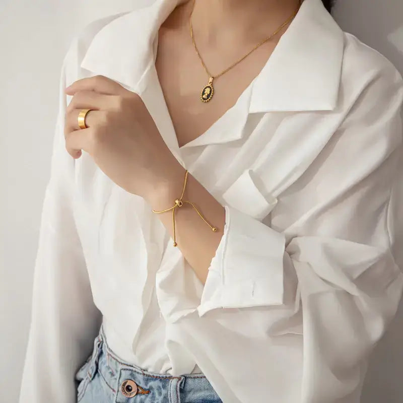 Model wearing thin rope bracelet gold