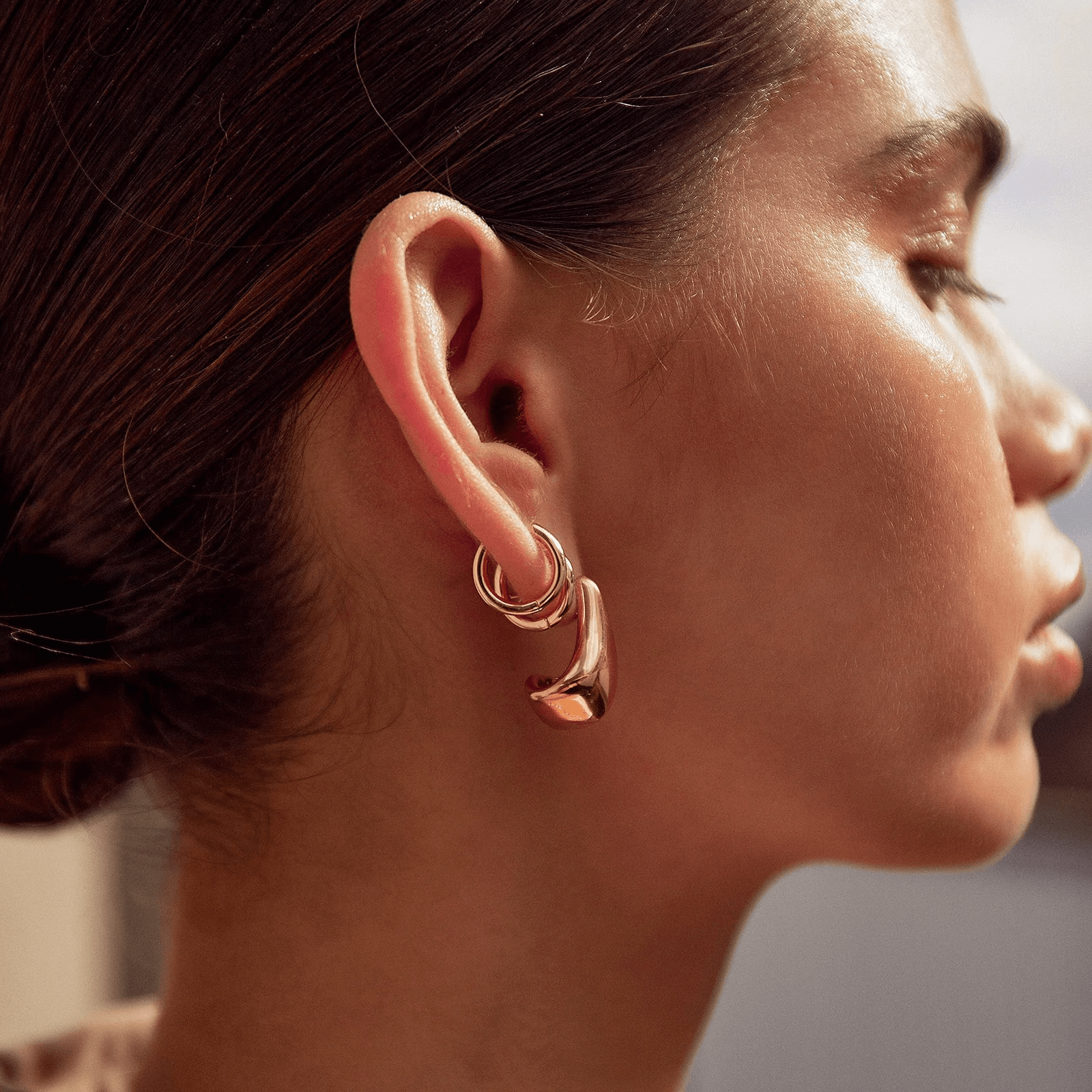 a woman showing her gold stack earrings