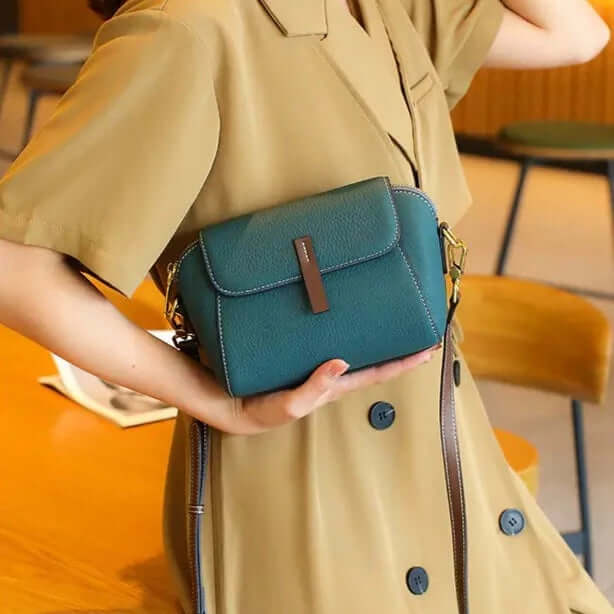 A woman carrying a blue mini crossbody bag