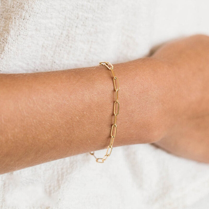 Model wearing gold paperclip bracelet